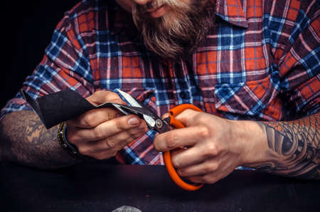 Worker of leather processes a workpiece from leatherの写真素材