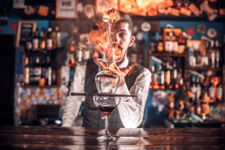 Charismatic tapster mixes a cocktail on the barの写真素材