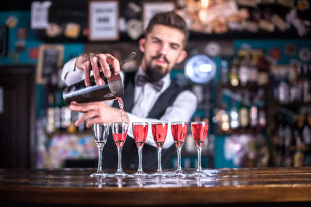 Confident Female bartender adds ingredients to a cocktail in the pubの写真素材