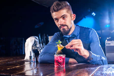 Charismatic barman formulates a cocktail in the night clubの写真素材