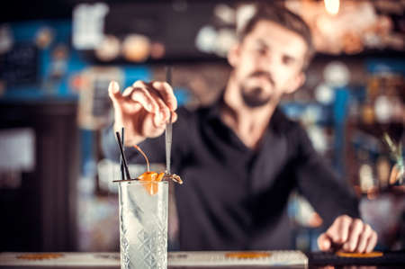 Expert tapster places the finishing touches on a drink on the bar
