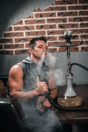 Brutal guy in the hookah room in cafe.の写真素材