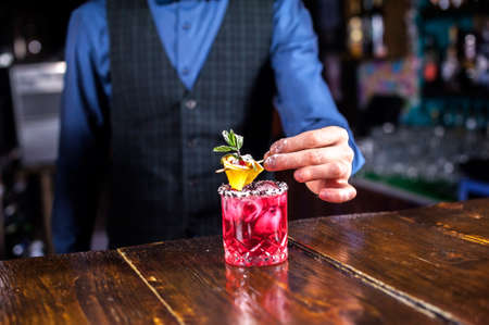 Charismatic barman is pouring a drink in cocktail barsの写真素材