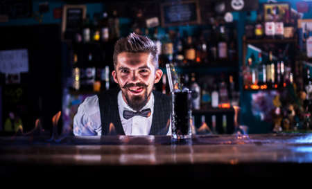 Charismatic Female bartender demonstrates the process of making a cocktail at barの写真素材