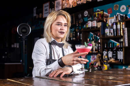Girl bartender mixes a cocktail at the taproomの写真素材