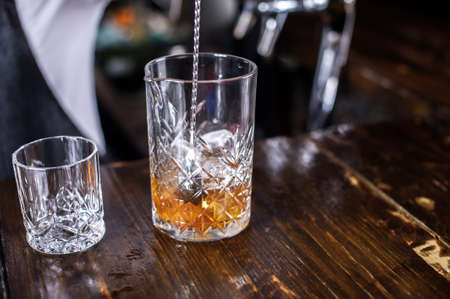 Charming woman mixologist demonstrates his skills over the counter behind the barの写真素材