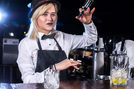 Girl barman makes a cocktail at the beerhouseの写真素材