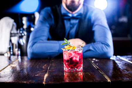 Professional barman creates a cocktail while standing near the bar counter in barの写真素材