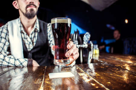Expert Female bartender formulates a cocktail while standing near the bar counter in barの写真素材