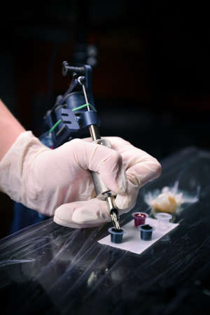 Professional Tattoo master is gaining the dye in to a tattoo machineの写真素材