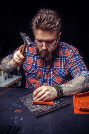 Craftsman working with leather working as artisanの写真素材