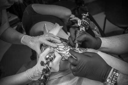 Tattoo specialist shows the process of tattooing studioの写真素材