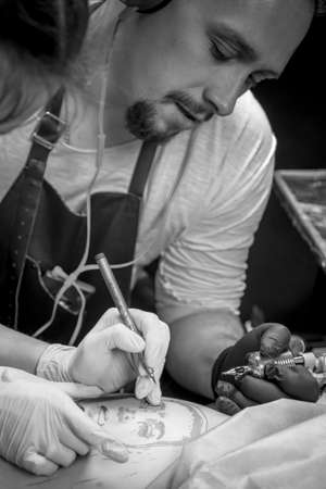 Tattoo specialist creating a tattoo on his client