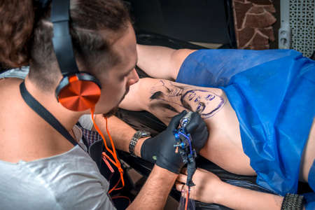 Professional tattooer working on professional tattoo machine device in tattoo studioの写真素材