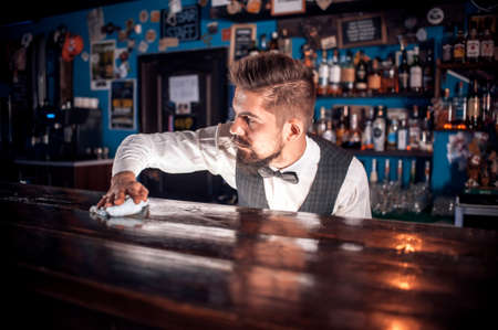 Bearded bartender surprises with its skill bar visitors behind the barの写真素材