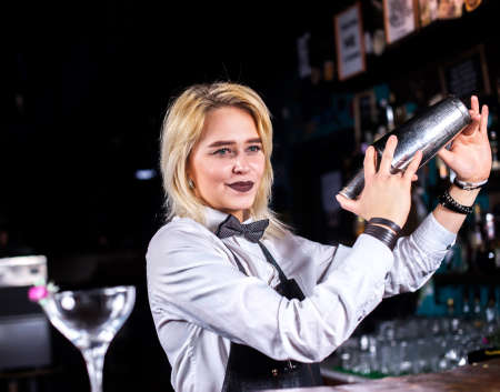 Girl barman formulates a cocktail at the beerhouseの写真素材