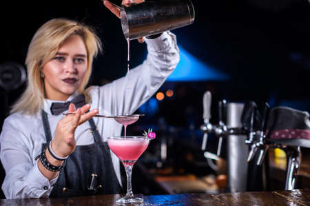 Girl bartender makes a cocktail on the barの写真素材