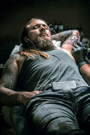Tattooer doing tattoo in tattoo studioの写真素材