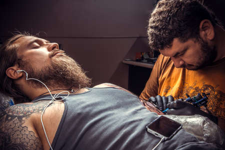 Tattooist at work in studioの写真素材