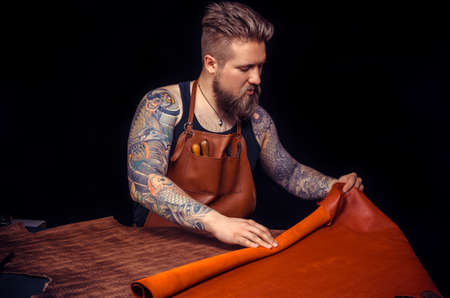 Leather Craftsman making quality products in workplaceの写真素材