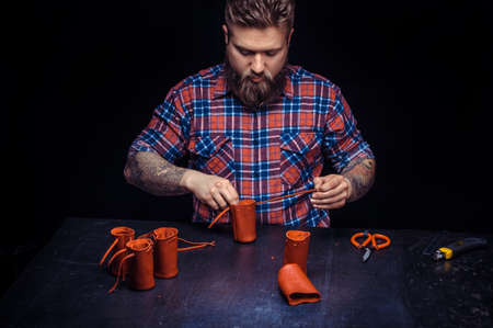 Leather workman forms new leather product at the leather studio