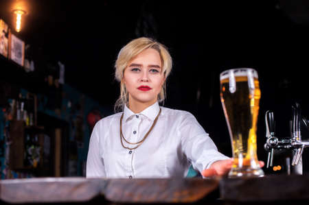 Girl barman formulates a cocktail on the alehouse