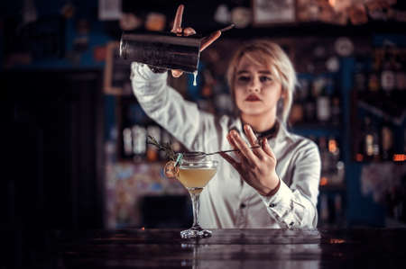 Girl barman mixes a cocktail on the beerhouseの写真素材