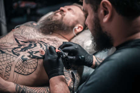 Tattoo artist makes cool tattoo in his salonの写真素材