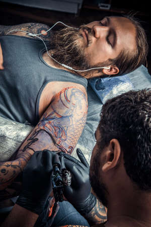 Tattoo specialist makes tattoo pictures in tattoo studio