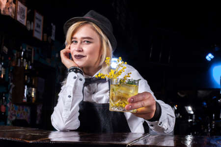 Girl bartender makes a cocktail on the brasserie