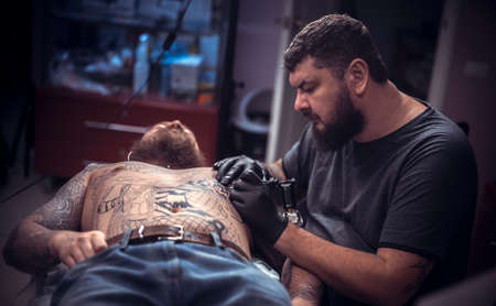 Tattoo artist making tattoo in salon his salonの写真素材