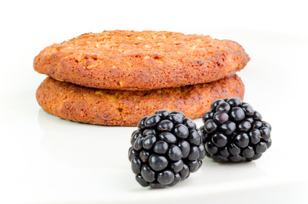 Two cookies with blackberries isolated on whiteの写真素材