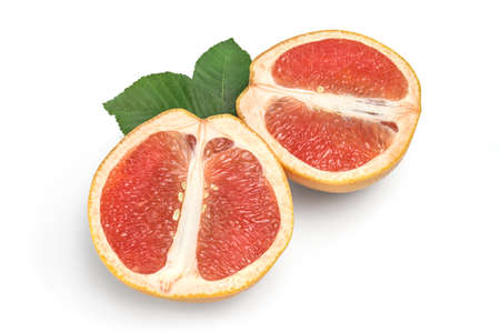 Two halves of grapefruit with green leaves isolated on white backgroundの写真素材