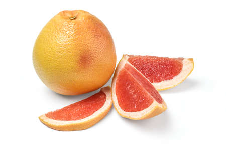 Whole grapefruit and wedges on whiteの写真素材
