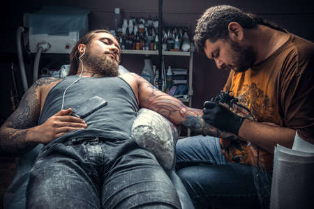 Tattooer posing in tattoo studioの写真素材