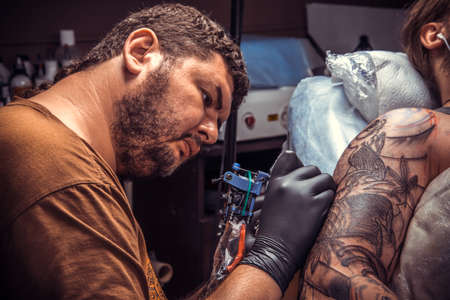 Professional tattoo artist works in tattoo parlorの写真素材