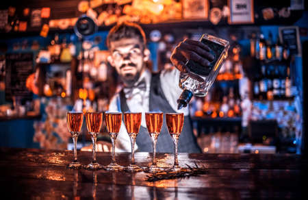Focused barman mixes a cocktail in cocktail barsの写真素材