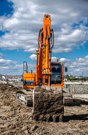 Big orange excavator against the blue skyの写真素材
