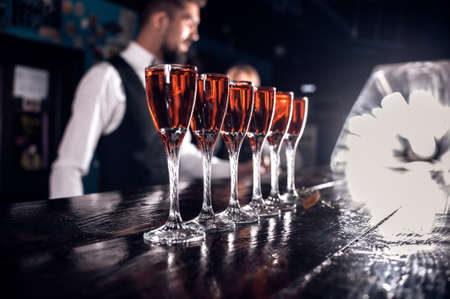 Young barman demonstrates his skills over the counter in the pubの写真素材