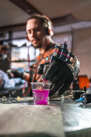 Hand of tattooer with a tattoo machine.の写真素材