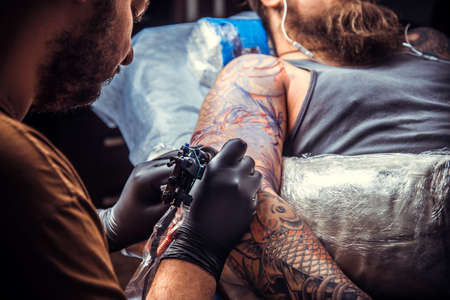 Tattoo master at work in tattoo parlorの写真素材