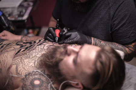 Professional tattooist making tattoo in salonの写真素材