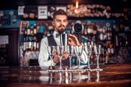 Charismatic bartender places the finishing touches on a drink in the night clubの写真素材