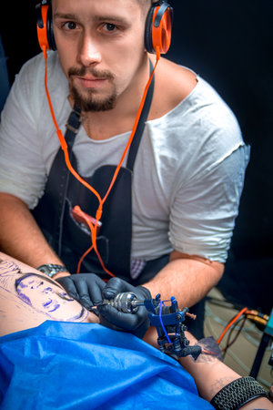 Professional tattooist makes tattoo pictures in tattoo parlorの写真素材