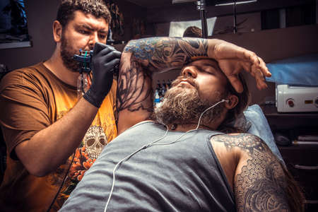 Tattooer working tattooing in tattoo parlorの写真素材