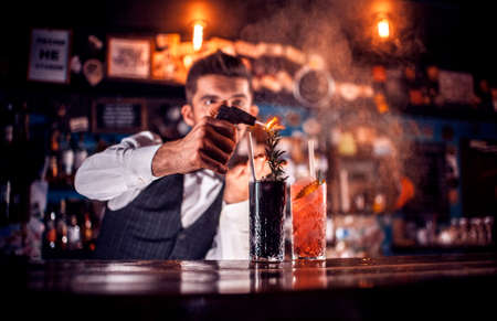 Professional Female bartender intensely finishes his creation at the nightclubの写真素材