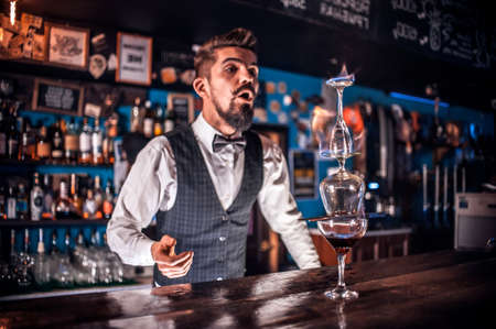 Focused bartending makes a cocktail in the nightclubの写真素材