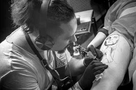 Master tattooist doing tattoo in tattoo parlorの写真素材