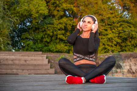 Beautiful sporty girl with headphones, listening to musicの写真素材