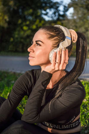 Smiling young woman outdoors with headphonesの写真素材